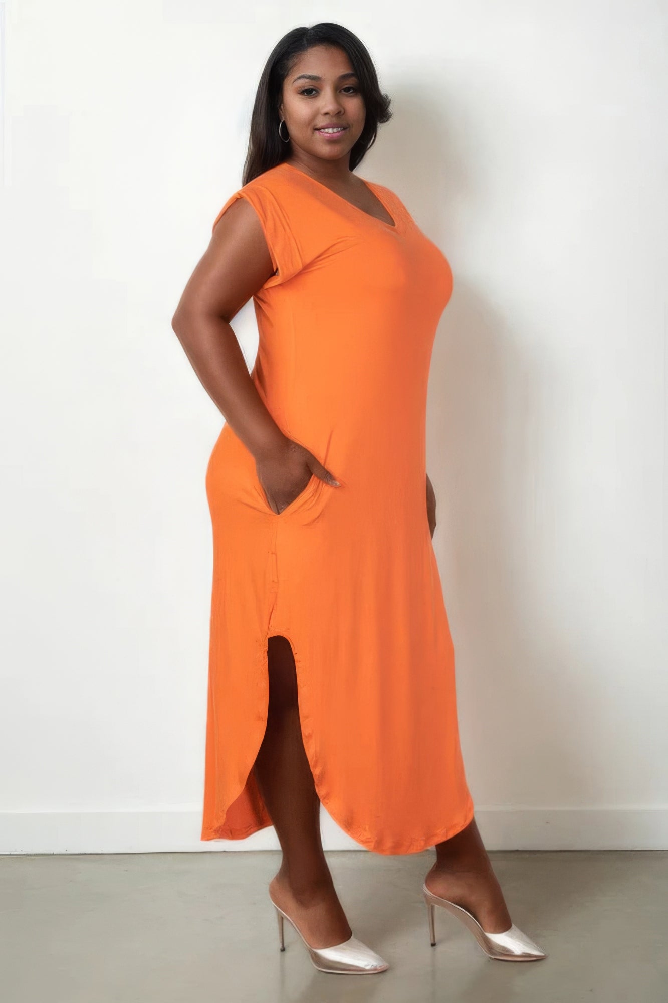 Plus size V-neck orange maxi dress with batwing sleeves and concealed pockets, modeled in a stylish and comfortable fit.