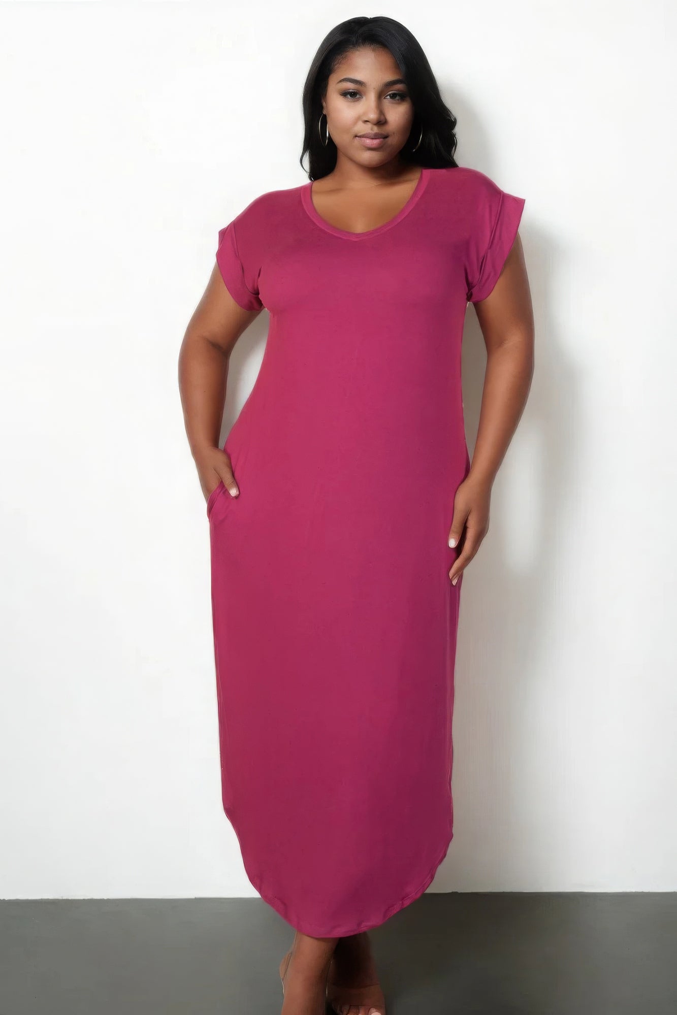 Plus size model wearing a chic magenta V-neck maxi dress with short sleeves and a flattering silhouette.