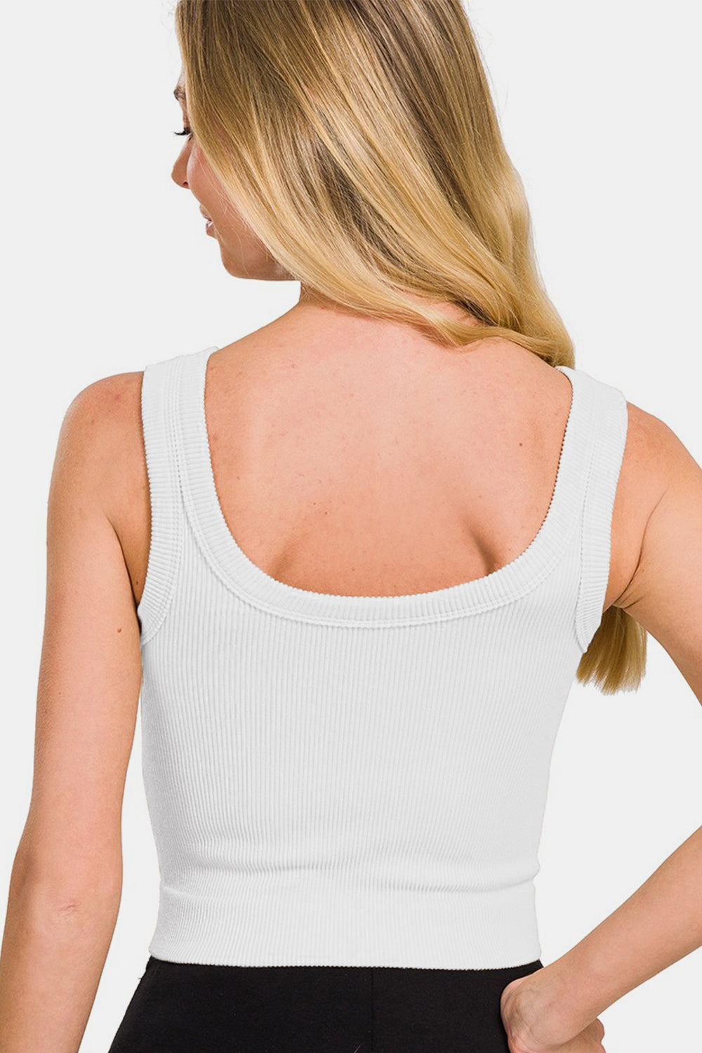 Woman wearing white ribbed round neck cropped tank, slightly stretchy fit, nylon and spandex blend.