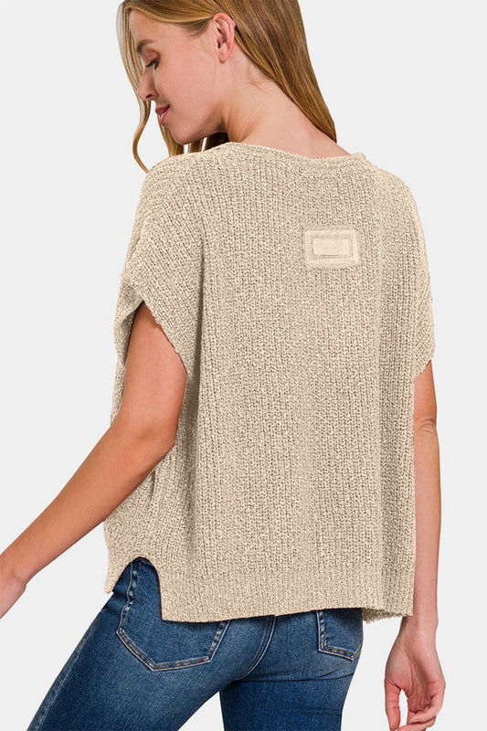 Woman wearing short sleeve side slit sweater with jeans, showcasing lightweight knit fabric and chic style.