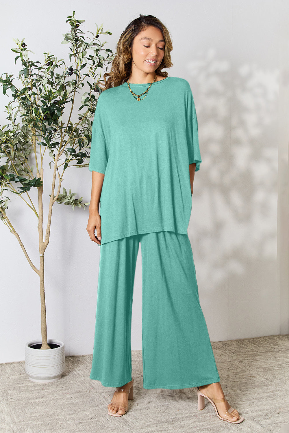 Woman in a trendy mint green round neck slit top and pants set, perfect for versatile day-to-night fashion.