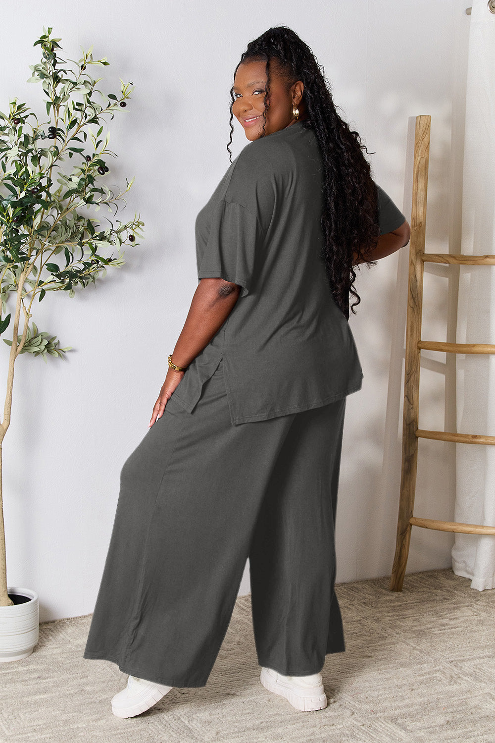 Woman wearing trendy round neck slit top and pants set in gray, showcasing versatile day-to-night fashion.