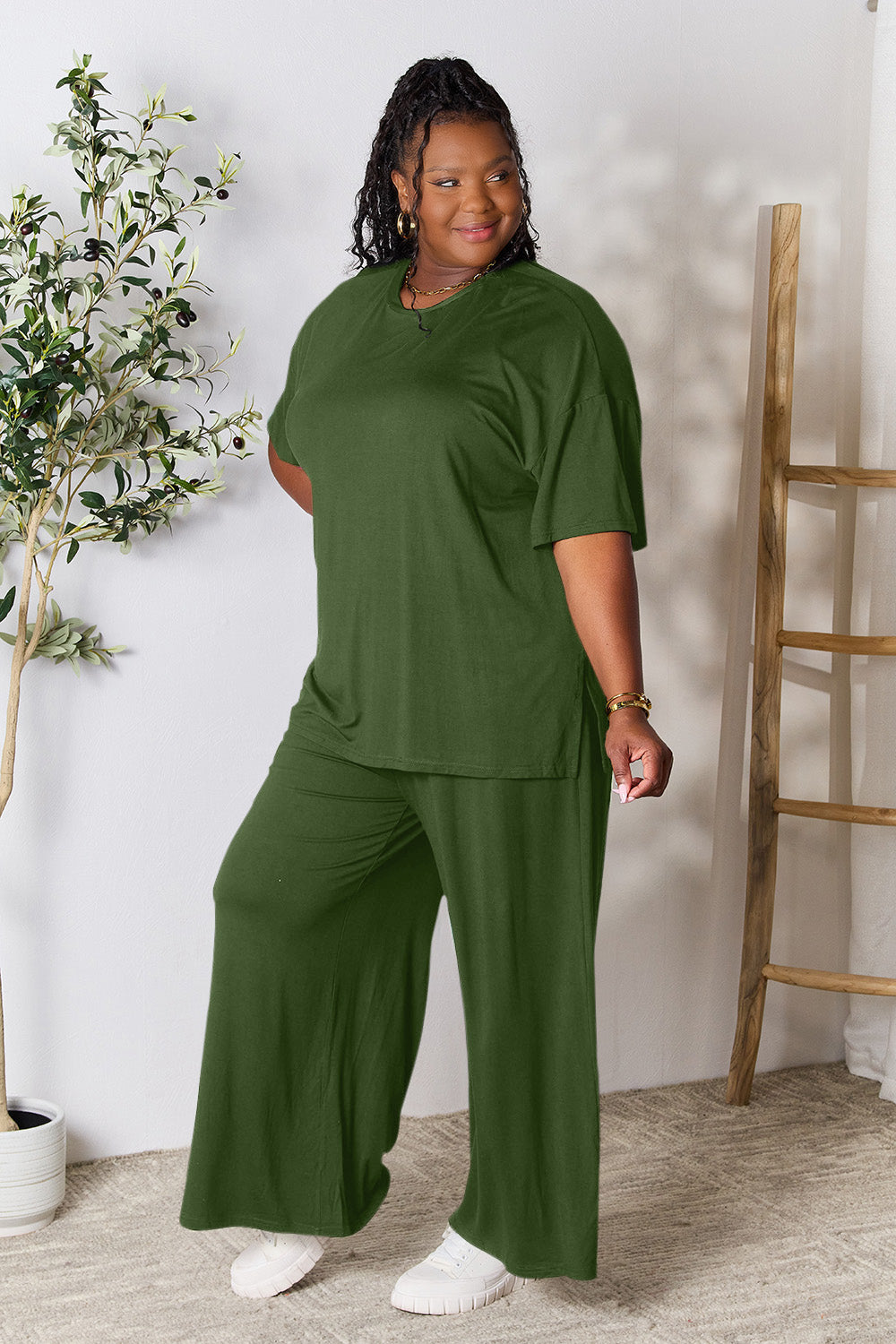 Woman wearing a stylish green round neck slit top and pants set indoors