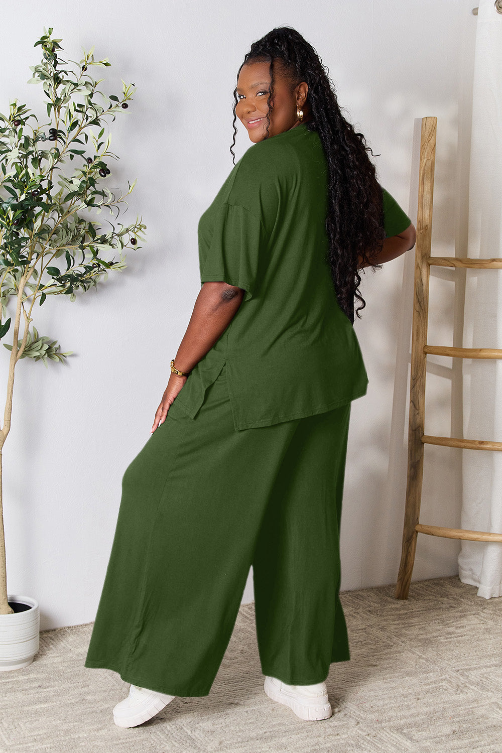 Woman wearing green round neck slit top and pants set, showcasing trendy two-piece outfit in a stylish and comfortable fit.