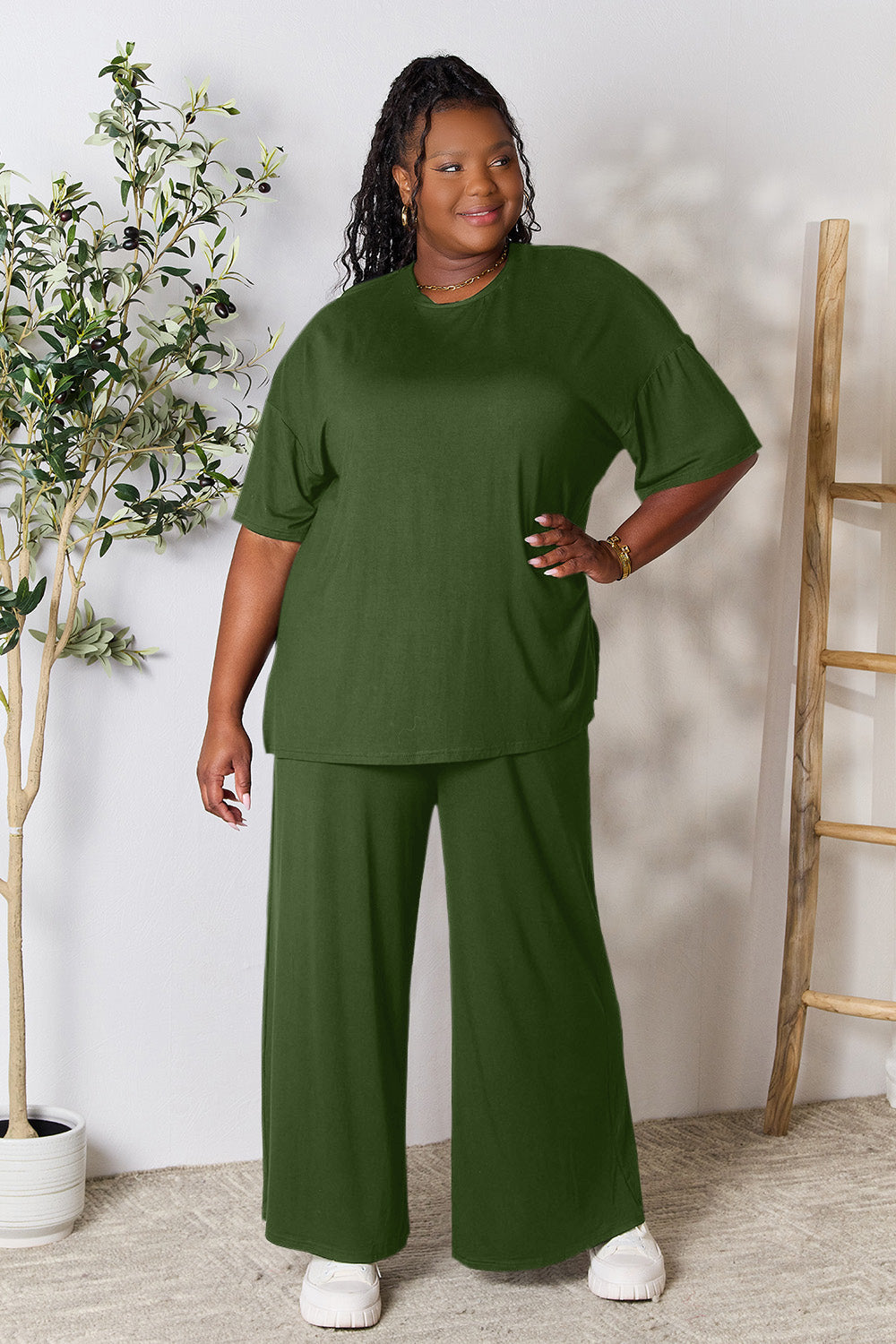 Woman wearing trendy green round neck slit top and pants set, comfortable fit, perfect for day-to-night fashion styling.