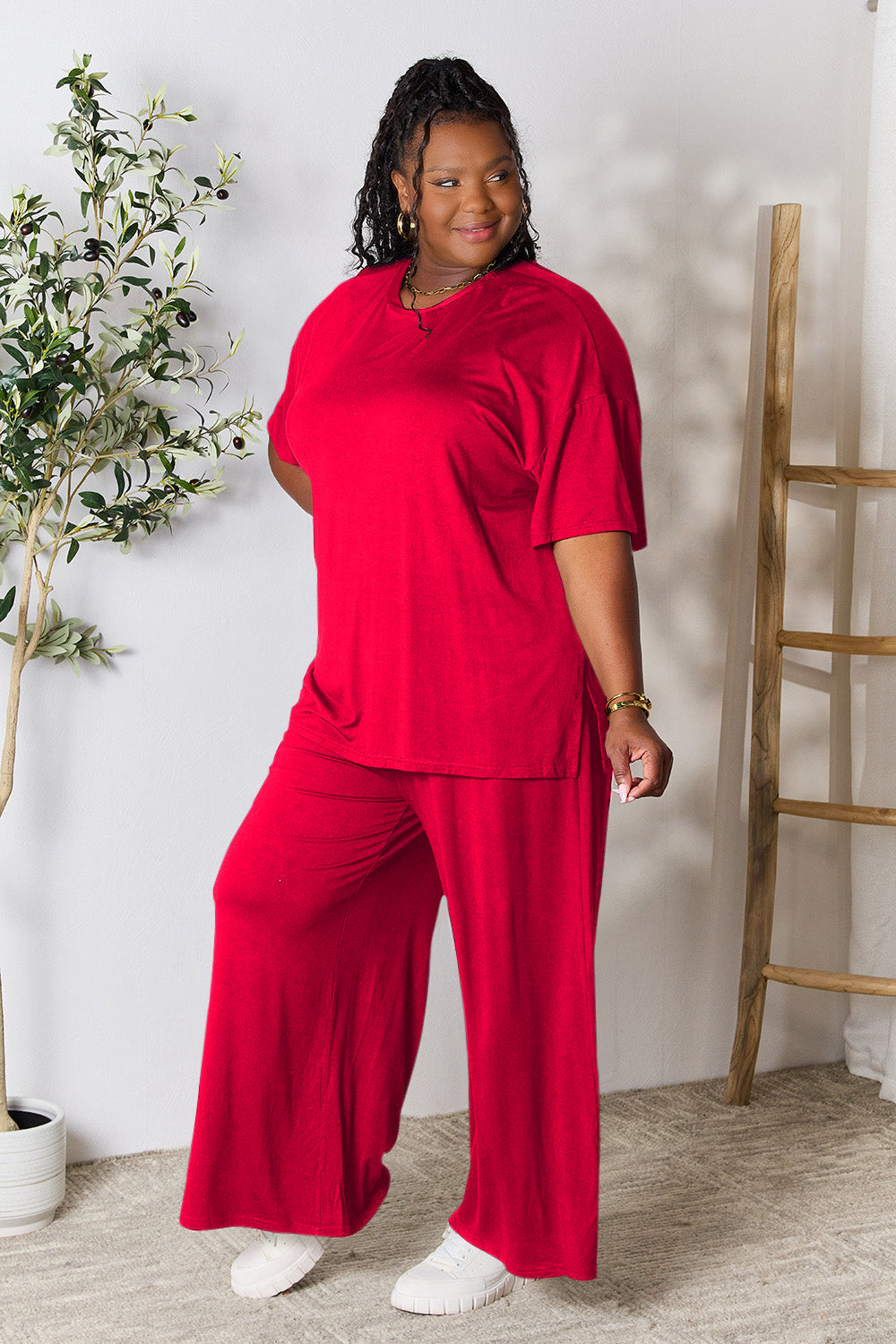 Woman wearing trendy red two-piece round neck slit top and pants set, perfect for day to night fashion.