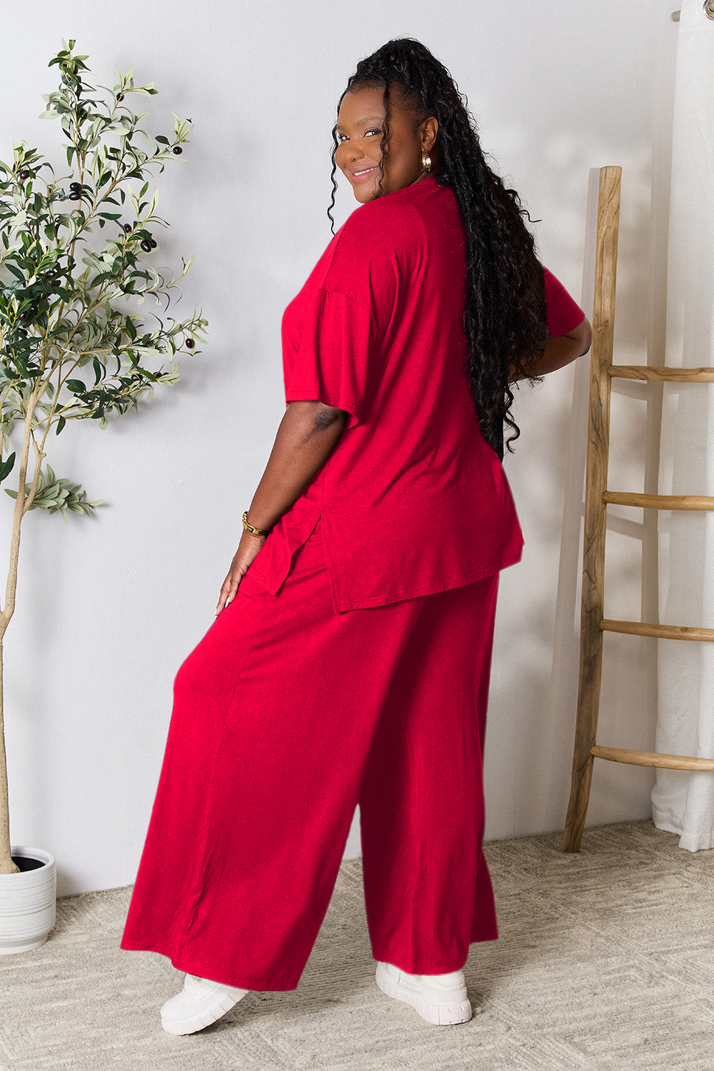 Woman modeling red round neck slit top and pants set in trendy two-piece outfit.