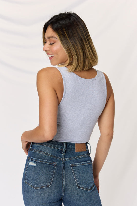 Woman wearing a gray square neck wide strap cropped cami and blue jeans, showcasing the back view of the outfit.