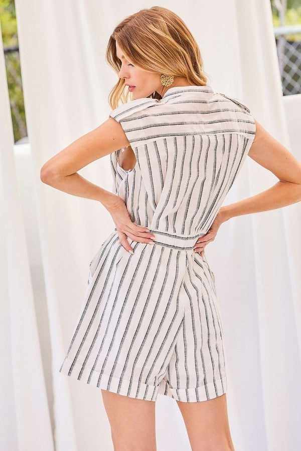 Woman wearing a notched neck button romper with elastic band waist and off-white stripe print, made of 100% rayon.