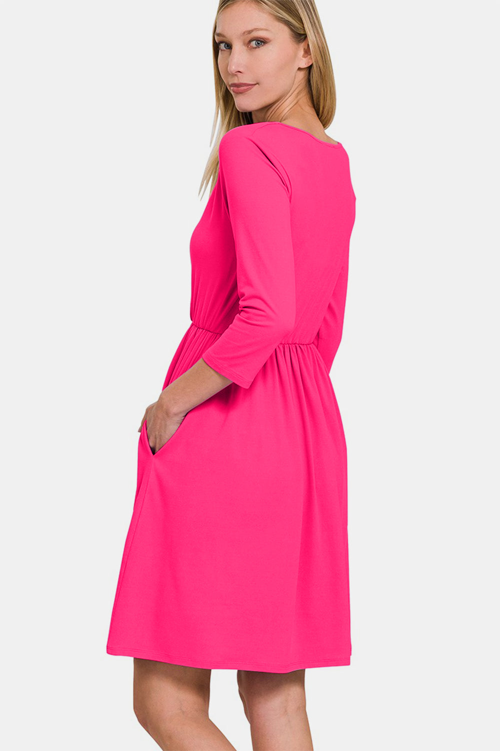 Woman wearing a pink three-quarter sleeve surplice dress with pockets, showcasing a flattering and elegant fit.