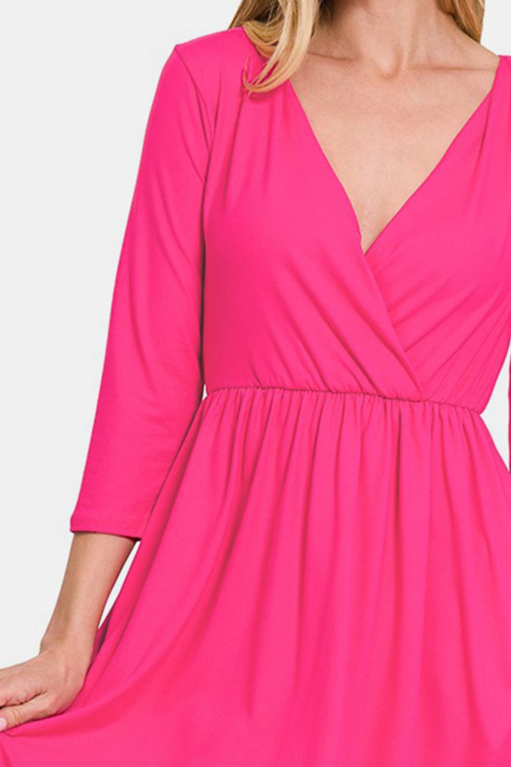 Pink three-quarter sleeve surplice dress with flattering neckline and ruched waist, featuring a chic and feminine design.