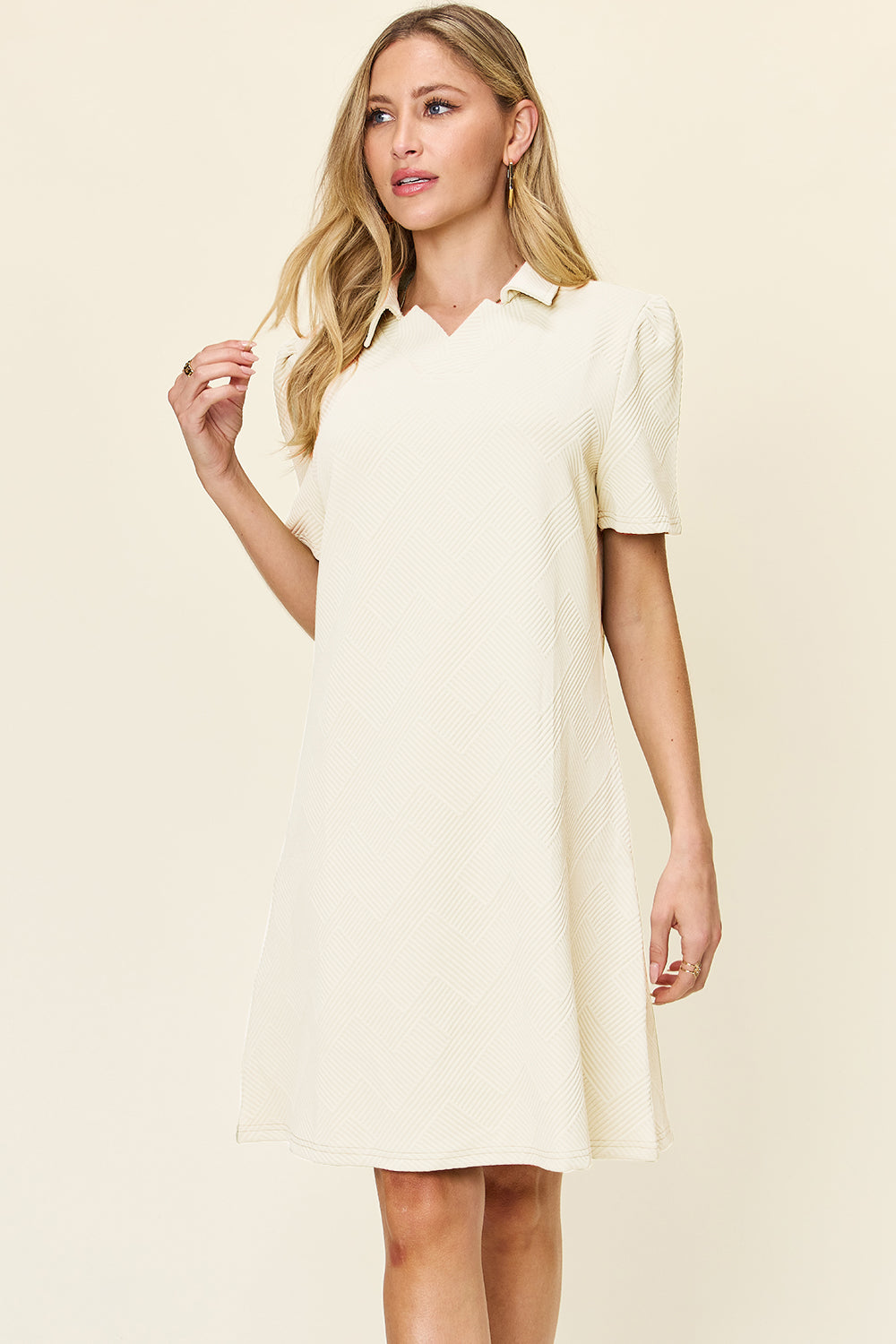 Woman wearing a texture collared neck short sleeve dress in light color, featuring a basic style with slightly stretchy polyester fabric.