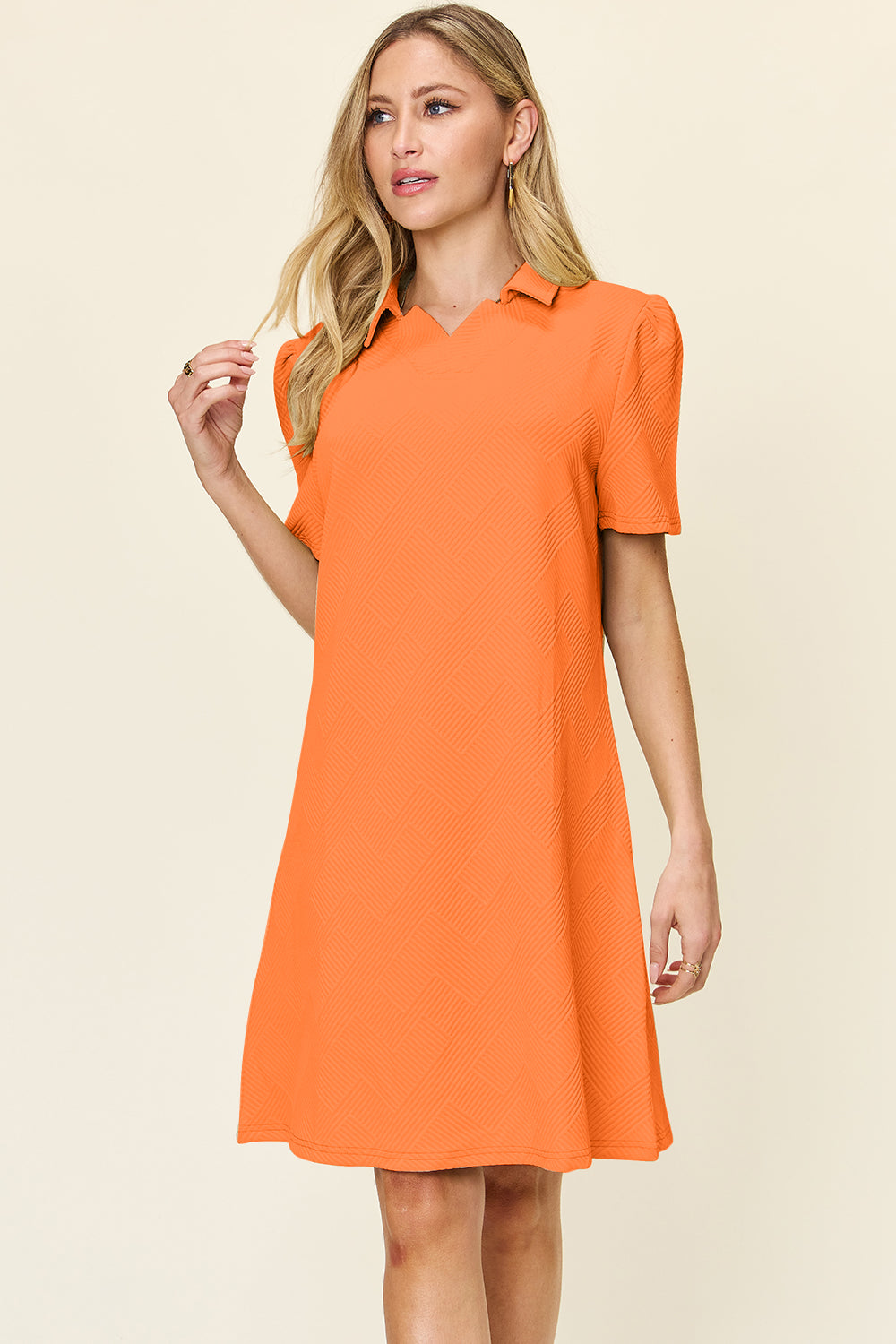 Woman wearing an orange texture collared neck short sleeve dress made of polyester and spandex.