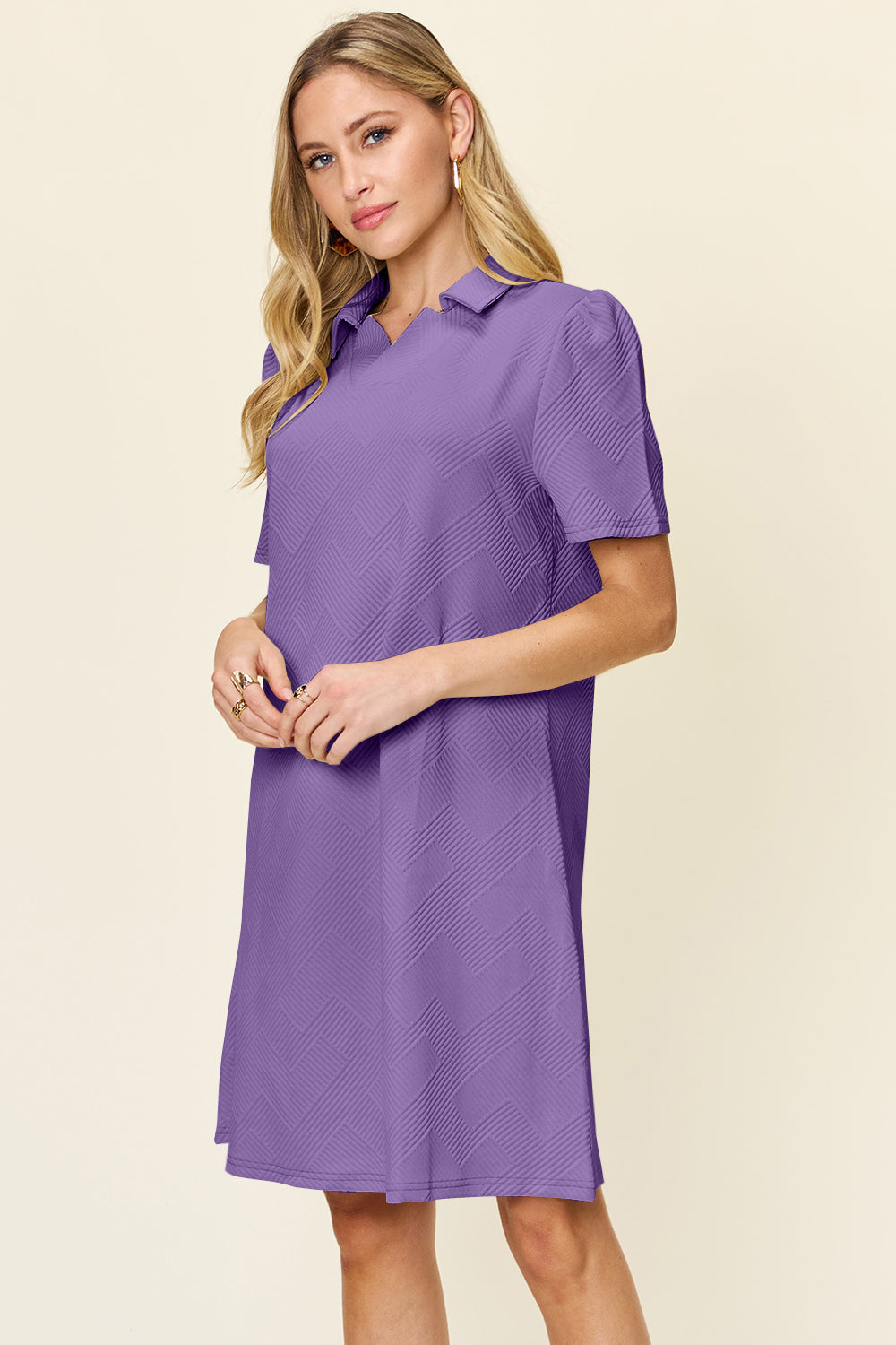 Woman wearing a texture collared neck short sleeve purple dress, slightly stretchy material, 98% polyester, 2% spandex.