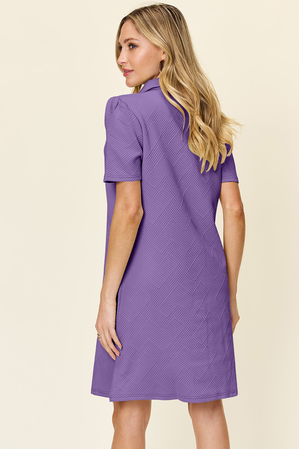 Woman wearing a purple texture collared neck short sleeve dress with a slightly stretchy fit