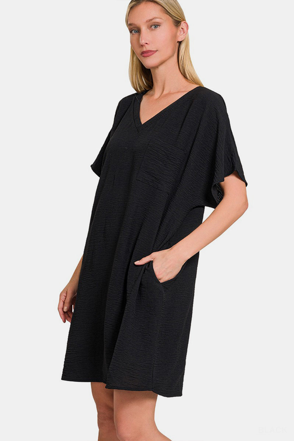 Black V-neck tee dress with pockets, crafted from lightweight polyester, featuring a classic silhouette and timeless style.