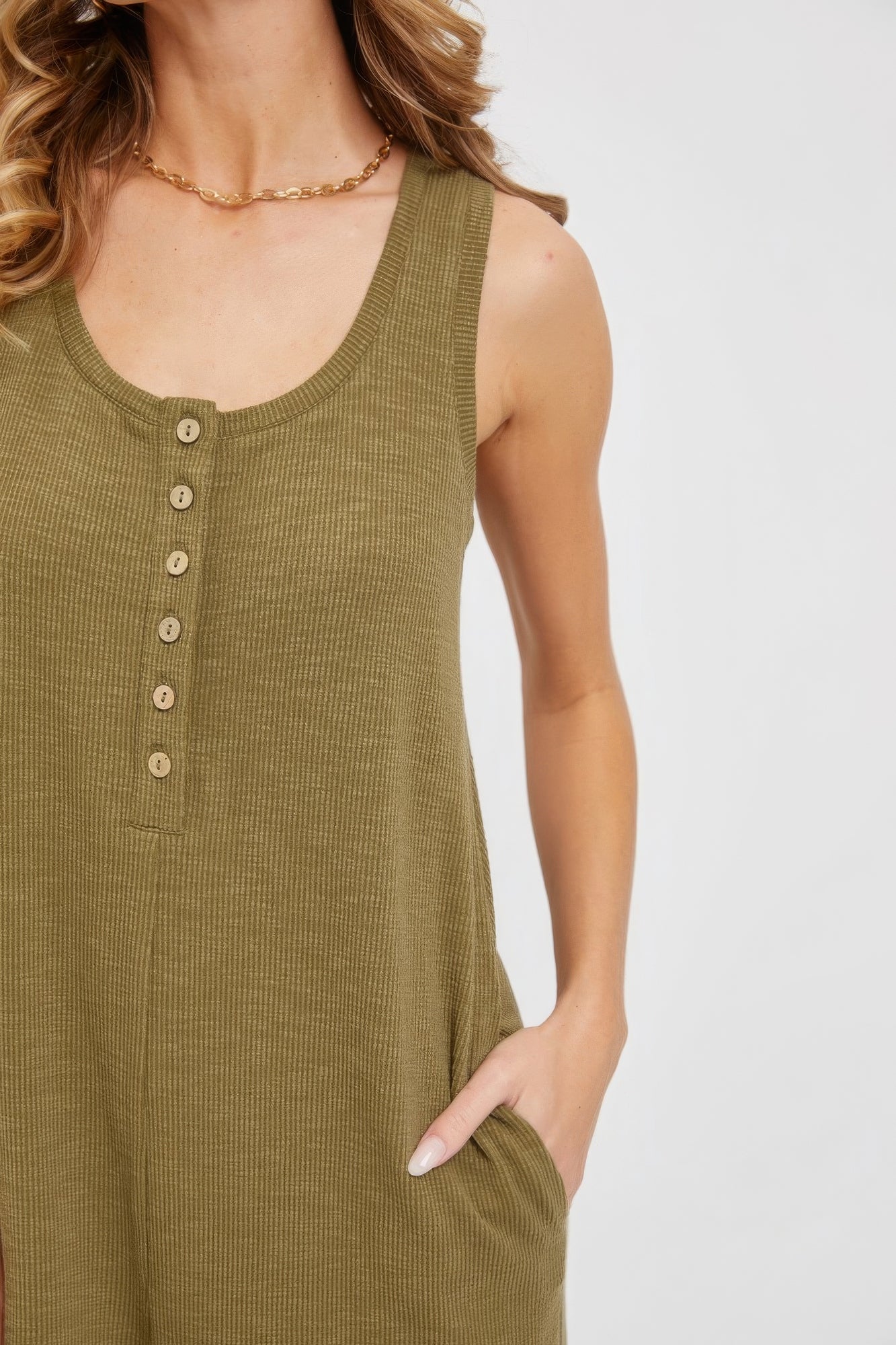 Olive green sleeveless buttondown jumpsuit with side pockets, showcasing a relaxed and comfy casual style for women.