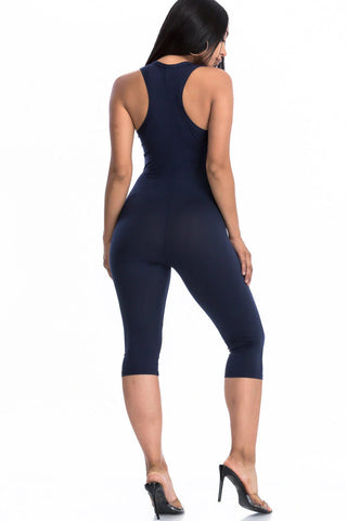 Woman wearing a navy chic capri jumpsuit with racer back design, showcasing a stylish silhouette, perfect for summer comfort.