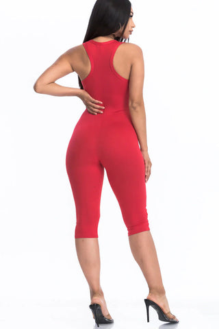 Woman in red racer back capri jumpsuit, showcasing lightweight jersey fabric, perfect for summer trends and casual wear.