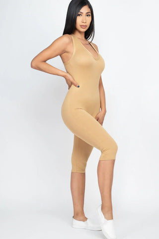 Woman wearing a chic beige capri jumpsuit with racer back, showcasing a flattering, comfortable fit perfect for summer fashion.