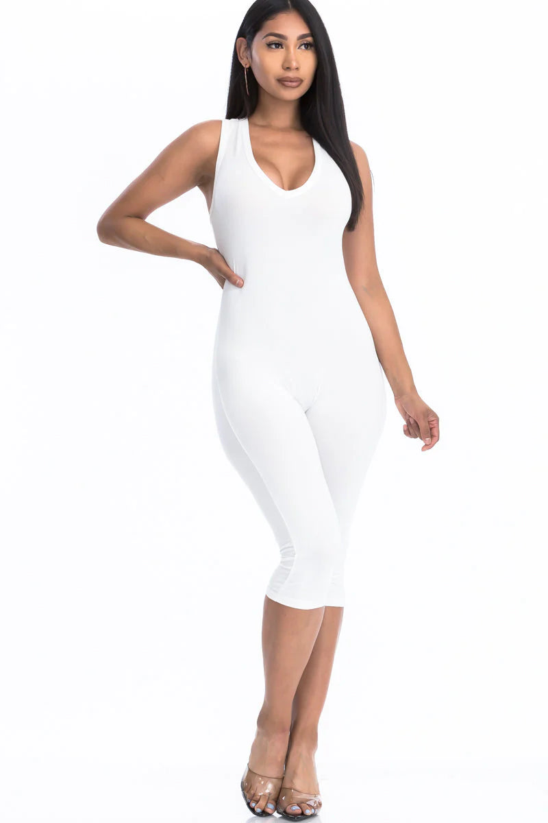 Woman wearing a chic white capri jumpsuit with racer back, showcasing a slenderizing silhouette and trendy summer style.