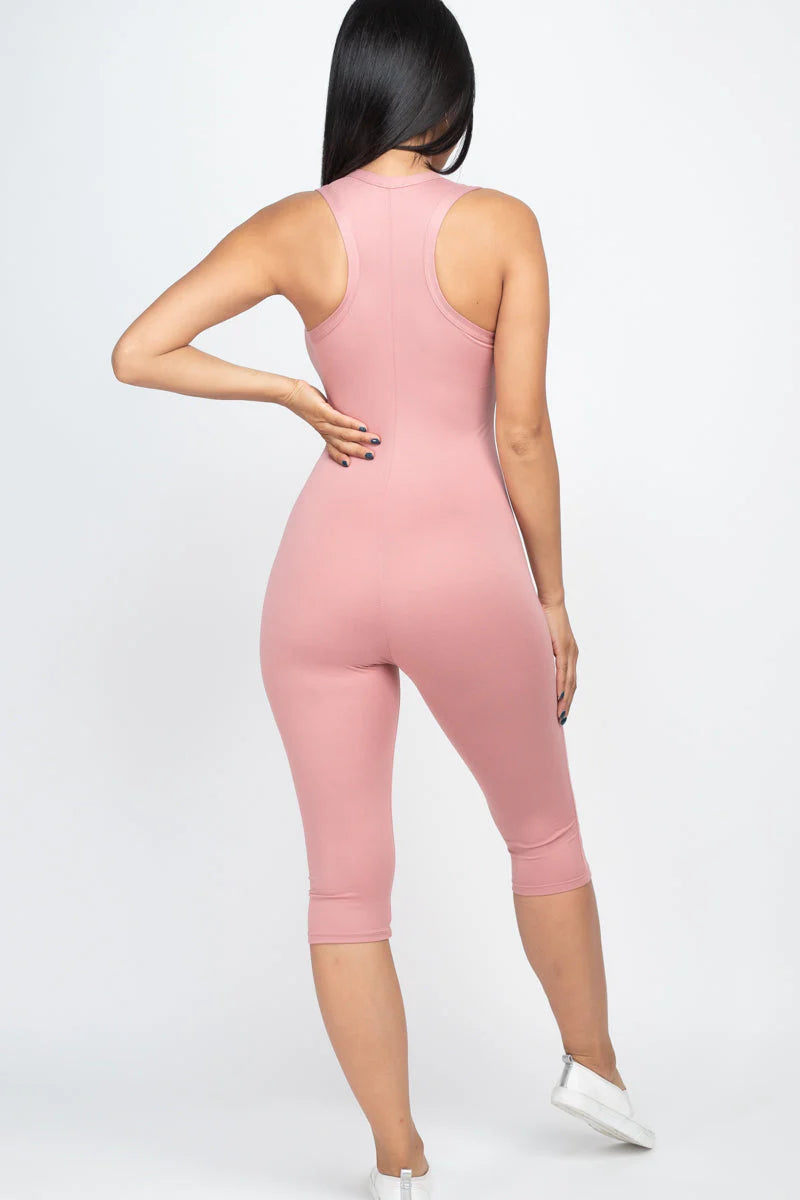 Woman wearing pink sleeveless racer back capri jumpsuit in soft jersey fabric, showcasing a slenderizing silhouette and comfortable fit.