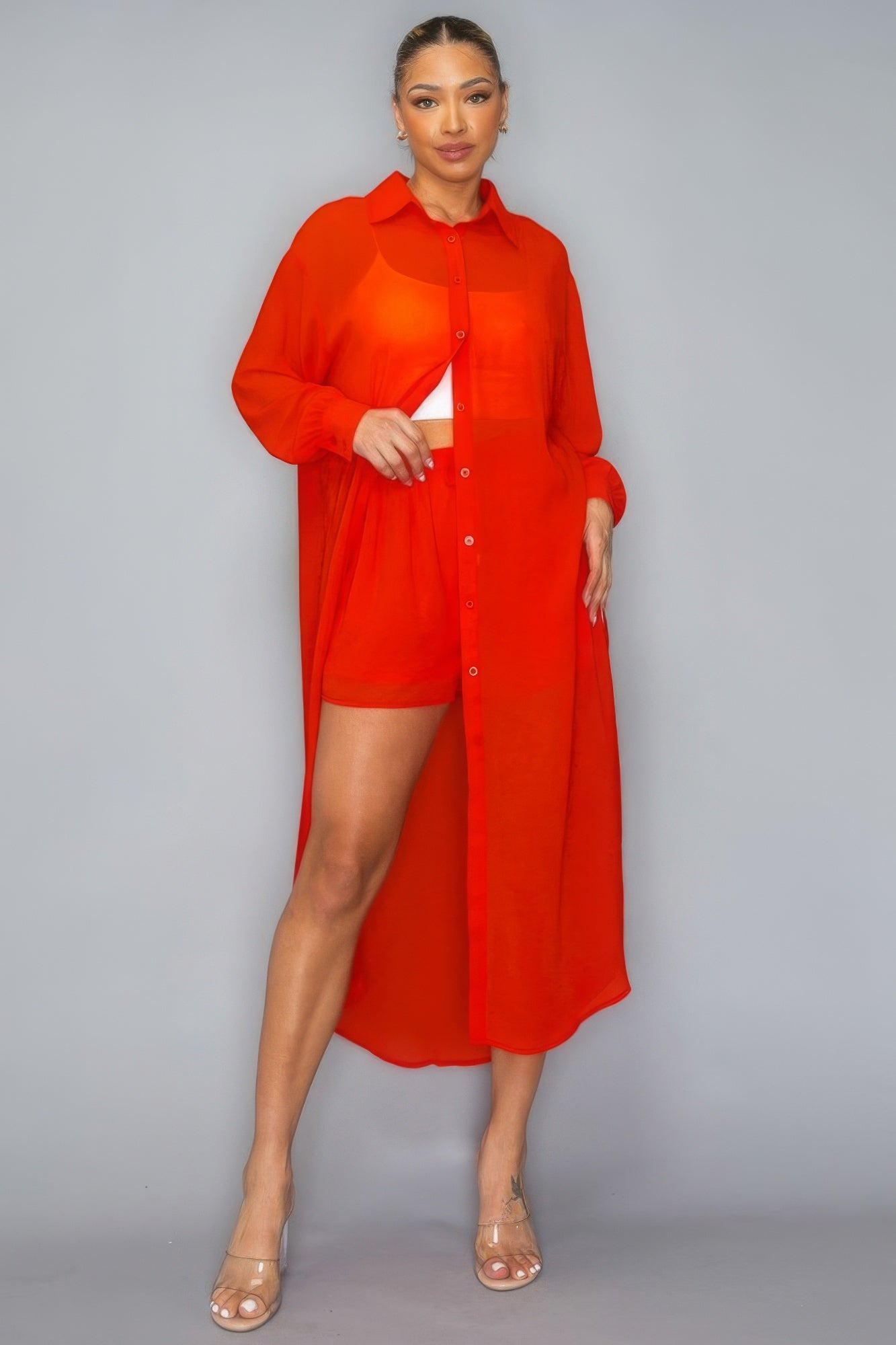 Woman wearing a red button down long sleeve side slit top and shorts set made of chiffon, showcasing stylish and comfortable all-day wear.