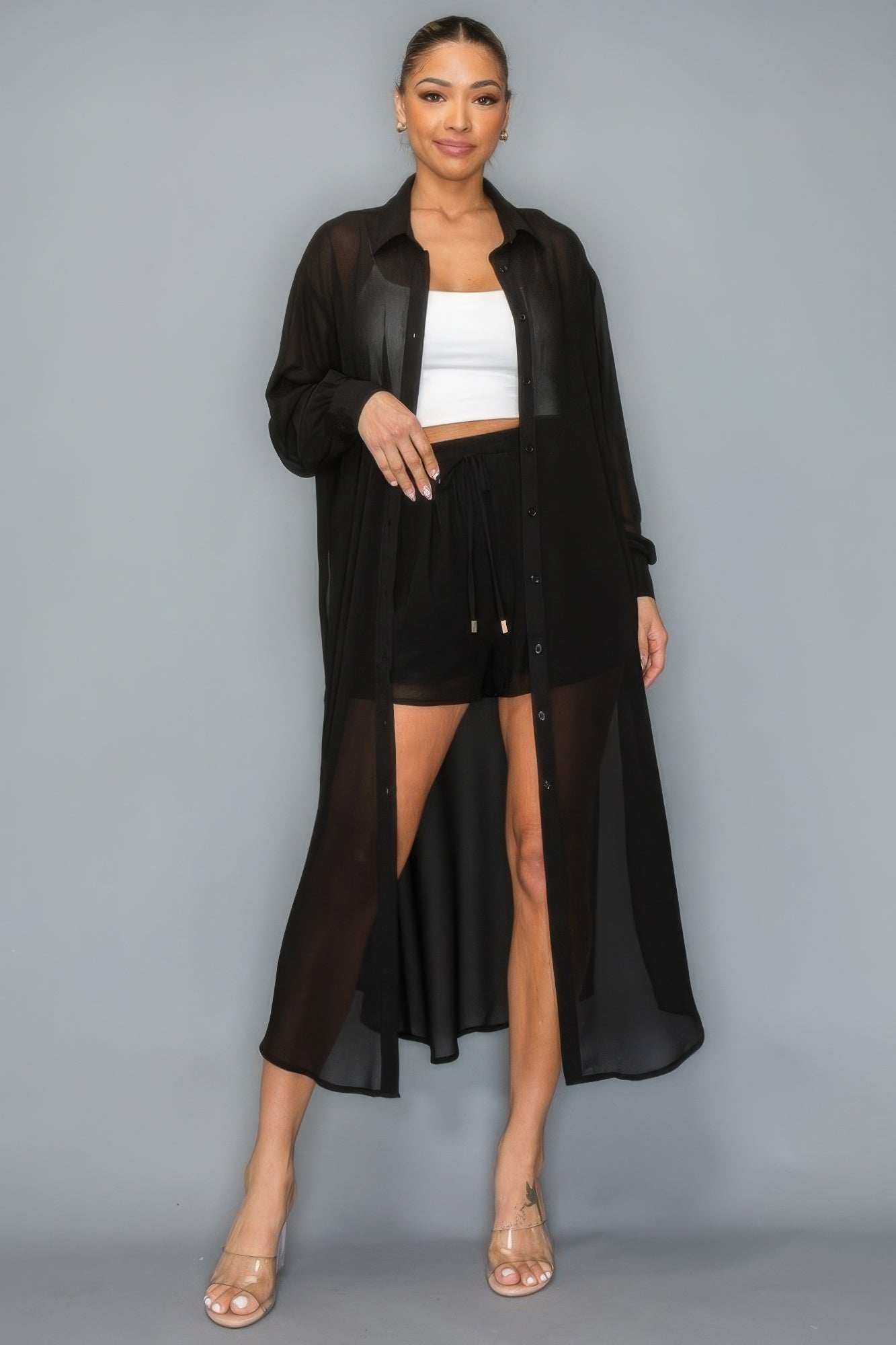 Woman wearing black button down long sleeve side slit chiffon two-piece set with shorts, showcasing comfortable and stylish design.