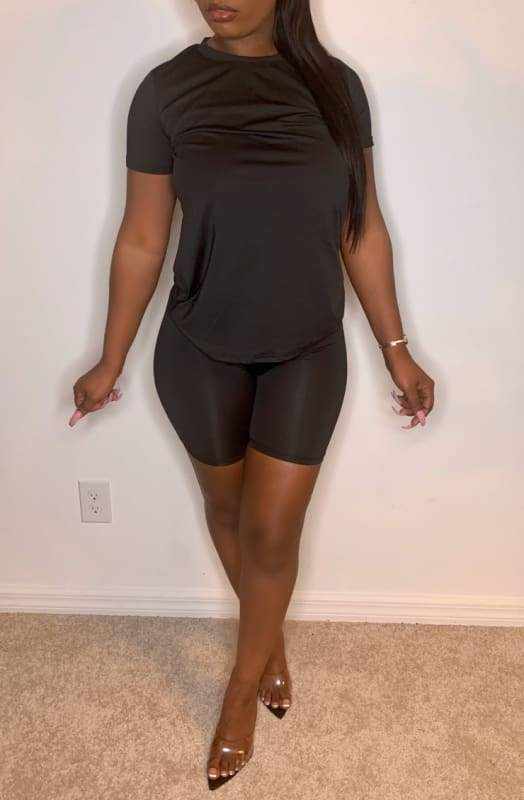 Woman wearing Chill Day Biker Short Set in black, featuring a solid top and biker shorts made of 96% polyester and 4% spandex.