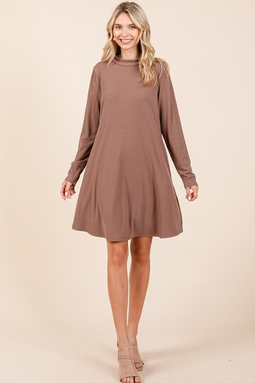 Cocoa mock neck long sleeve dress with pockets, slightly stretchy, made of polyester, rayon, spandex, worn by smiling woman.