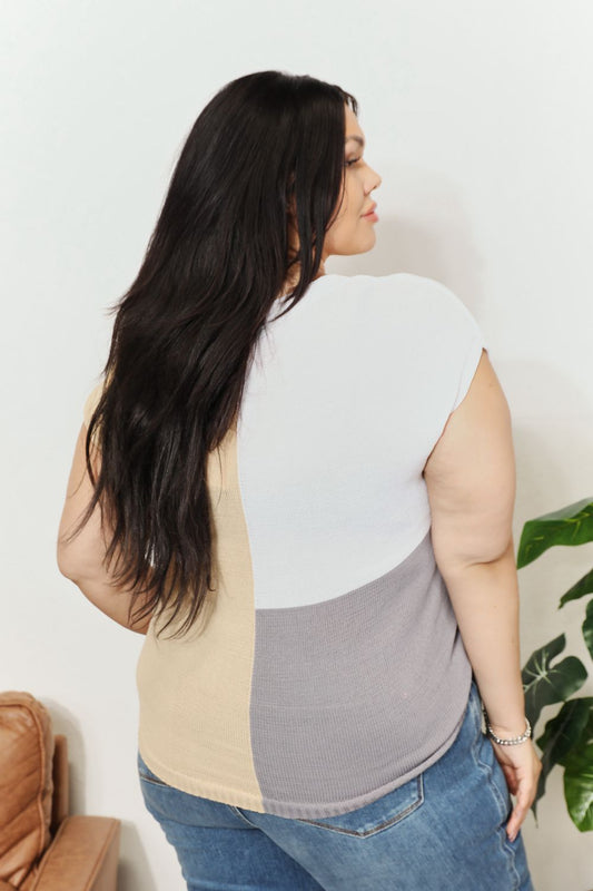 Woman wearing a color block V-neck knit top with short sleeves, showcasing a modern and stylish design, perfect for casual wear.