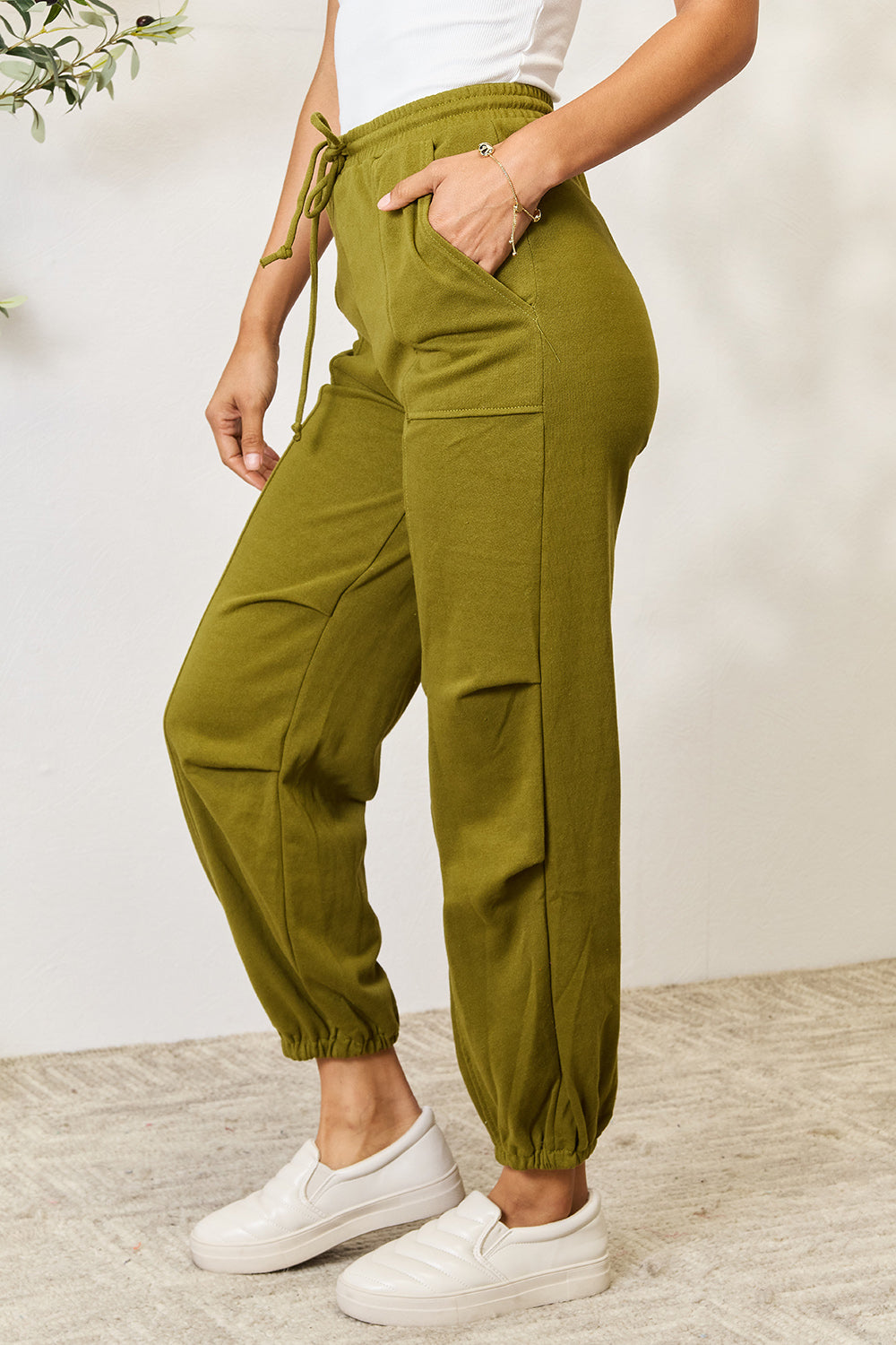 Olive green drawstring sweatpants with pockets, full size, made of 60% cotton and 40% polyester, perfect for casual style.