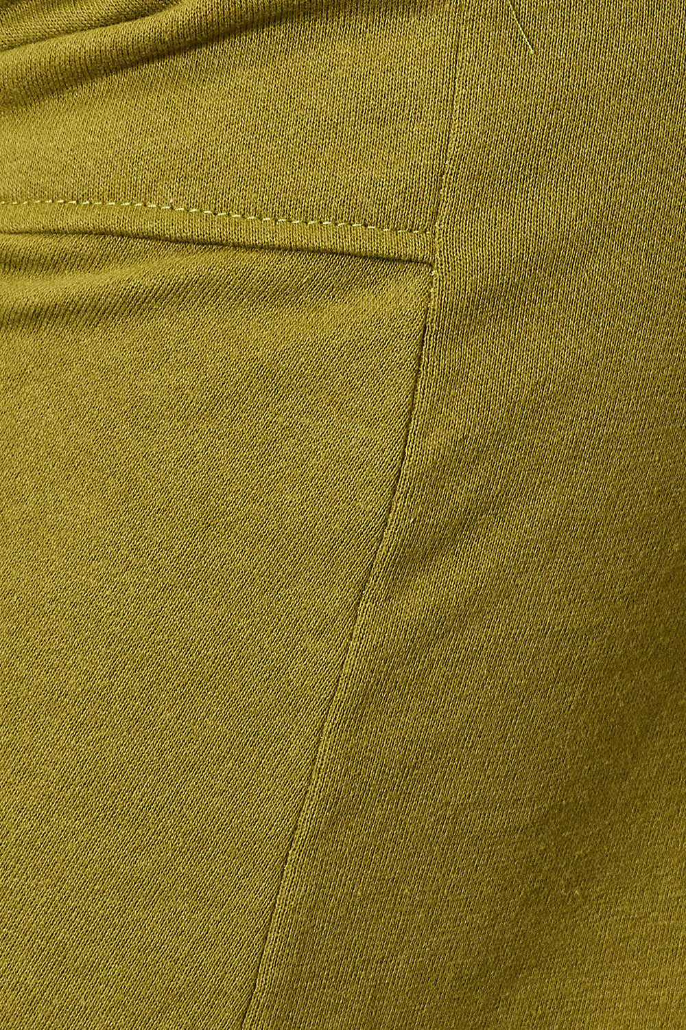 Close-up of green drawstring sweatpants with pockets, showcasing opaque cotton-polyester blend fabric.