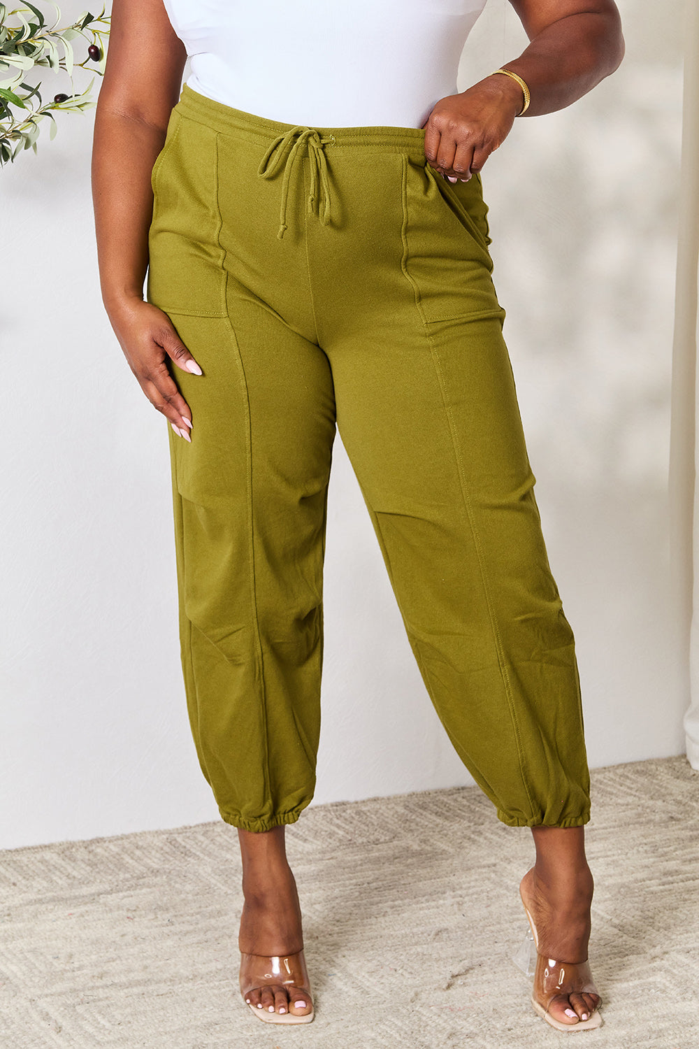 Olive green drawstring sweatpants with pockets, featuring a basic style and full size fit, made of 60% cotton and 40% polyester.