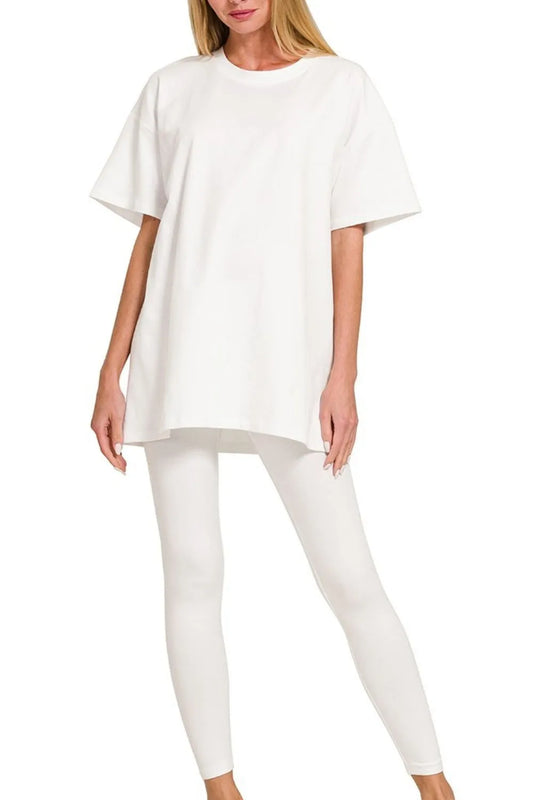 Woman wearing oversized white t-shirt and white leggings in relaxed pose against plain white background