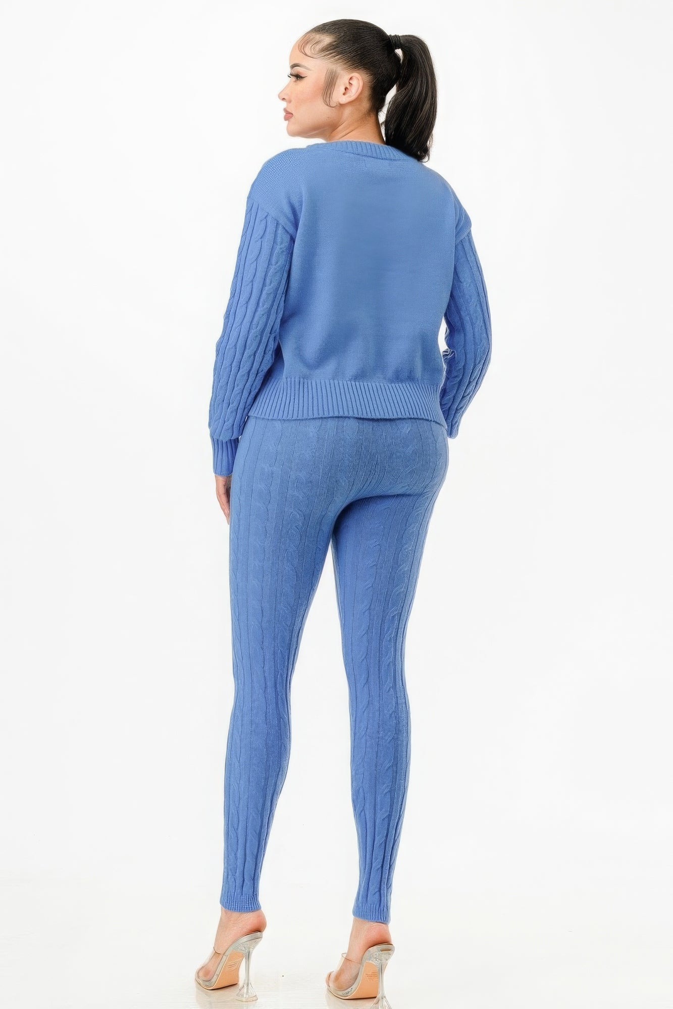 Woman wearing blue cable knit sweater and pants set, showcasing classic pattern and cozy fit.