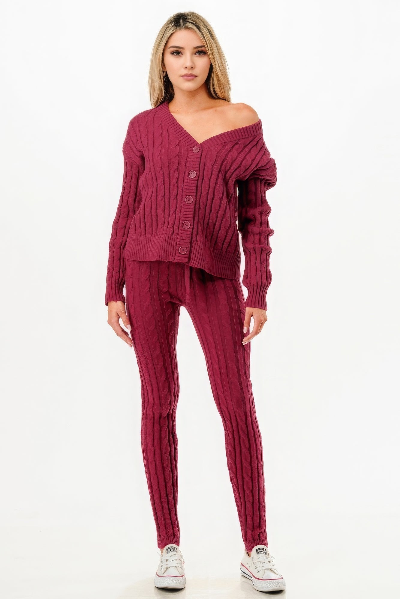 Woman wearing a wine-colored cable knit sweater cardigan 2pc set, featuring cozy polyester blend and classic pattern, styled with sneakers.