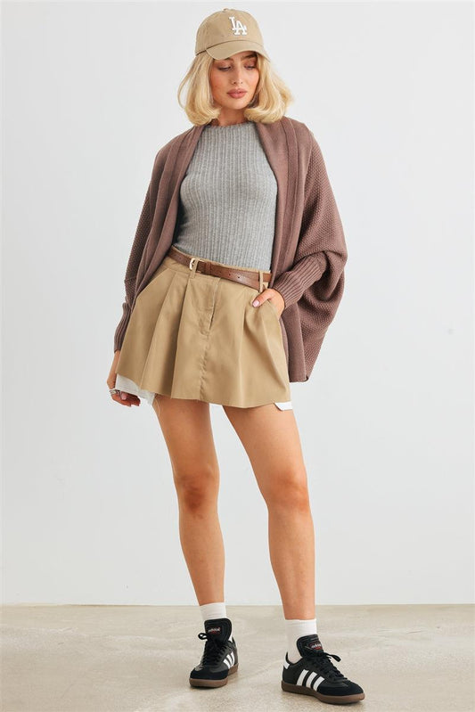 Woman wearing cozy batwing sleeve open front cardigan with skirt and cap, styled for a casual look.