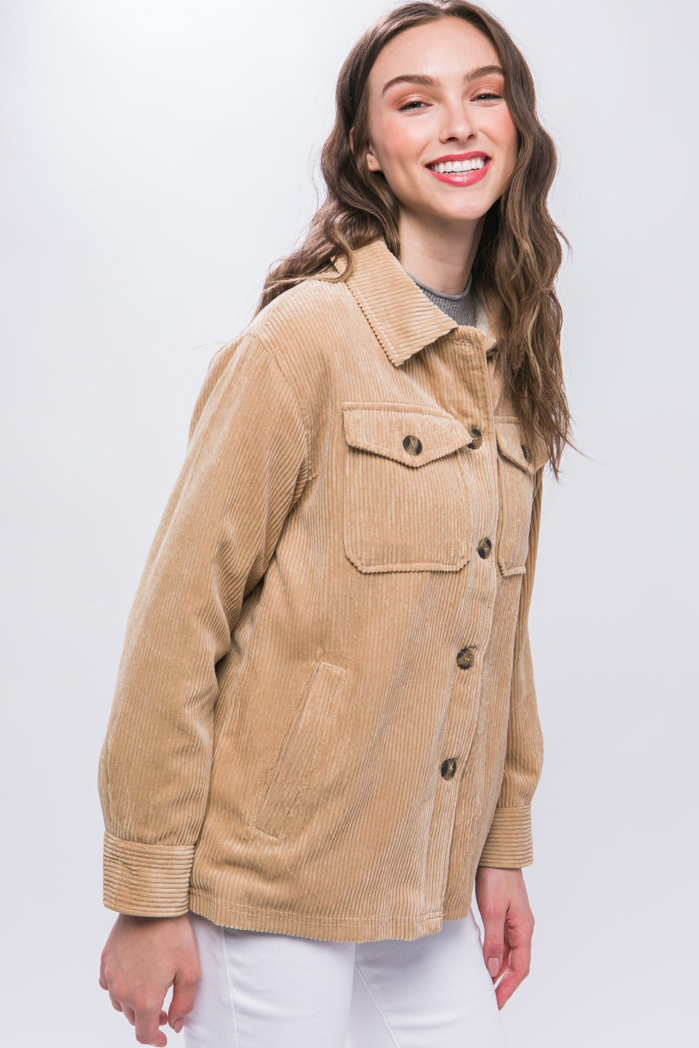 Woman wearing a beige corduroy button-up jacket with sherpa lining, showcasing a stylish and warm outfit ideal for chilly days.