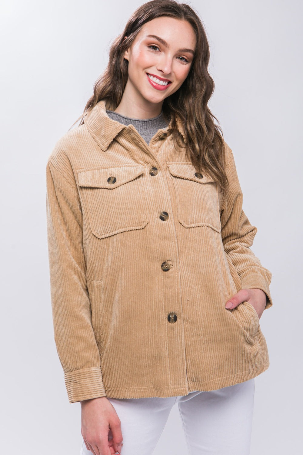 Woman wearing a beige corduroy button-up jacket with sherpa lining, showcasing a stylish and warm outerwear option.