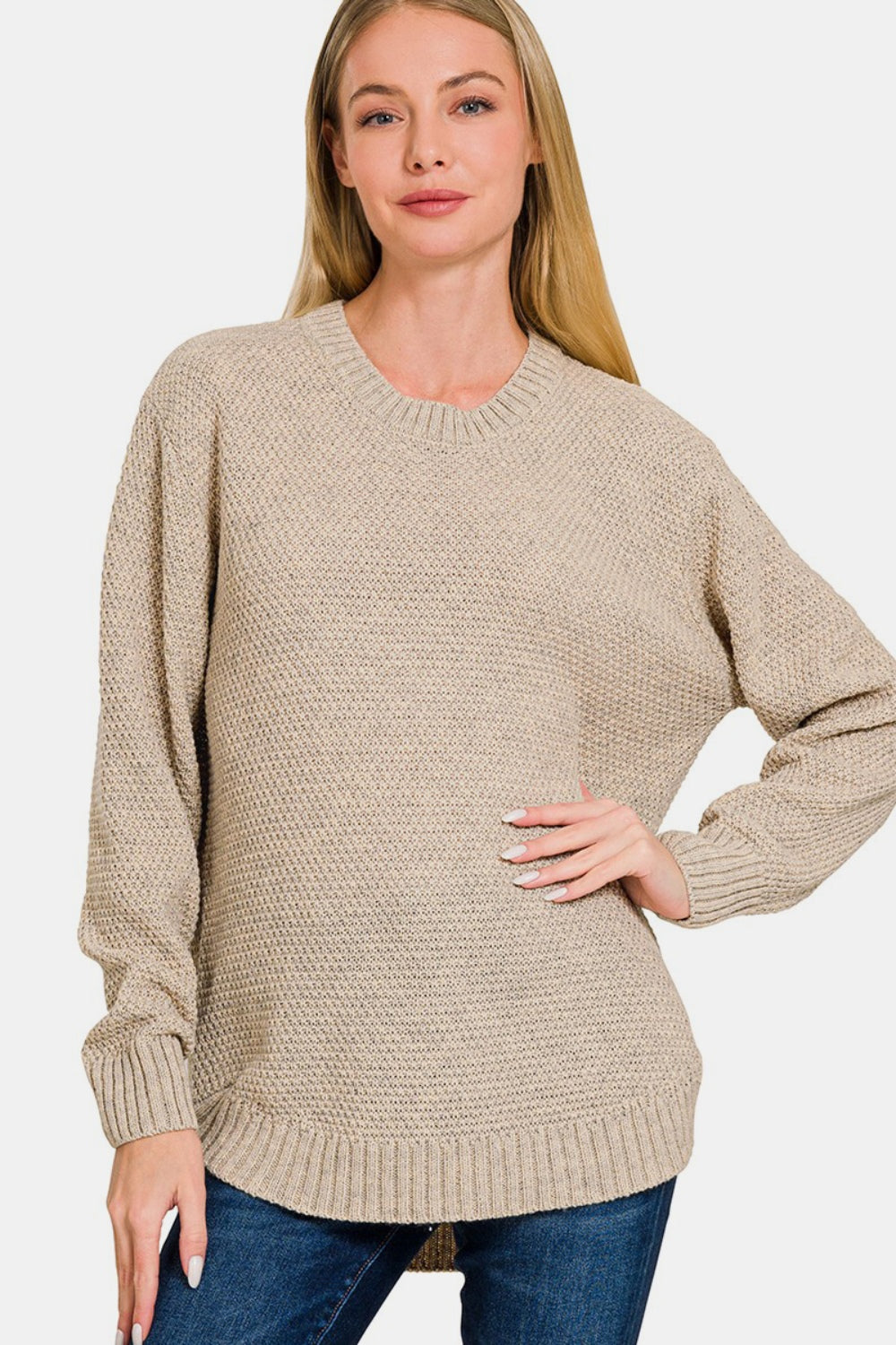 Woman wearing a round neck long sleeve curved hem sweater in beige, showcasing timeless style and comfort for everyday wear.