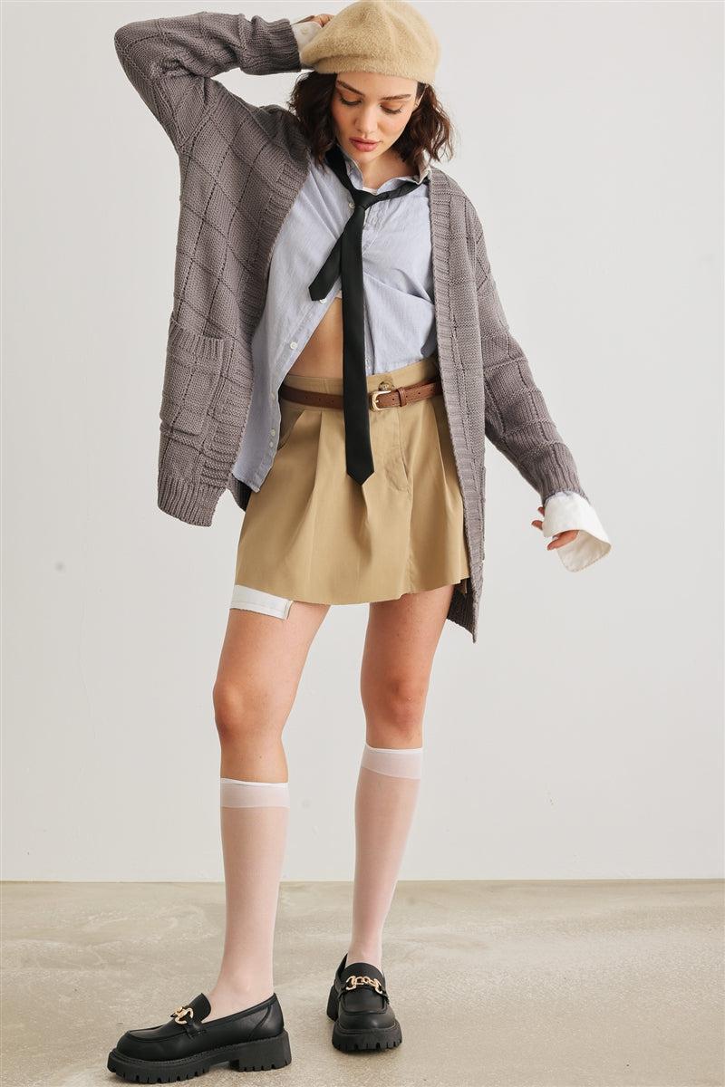 Stylish outfit with a cozy knit two pocket long sleeve cardigan, open front, paired with a shirt, tie, skirt, and knee-high socks.