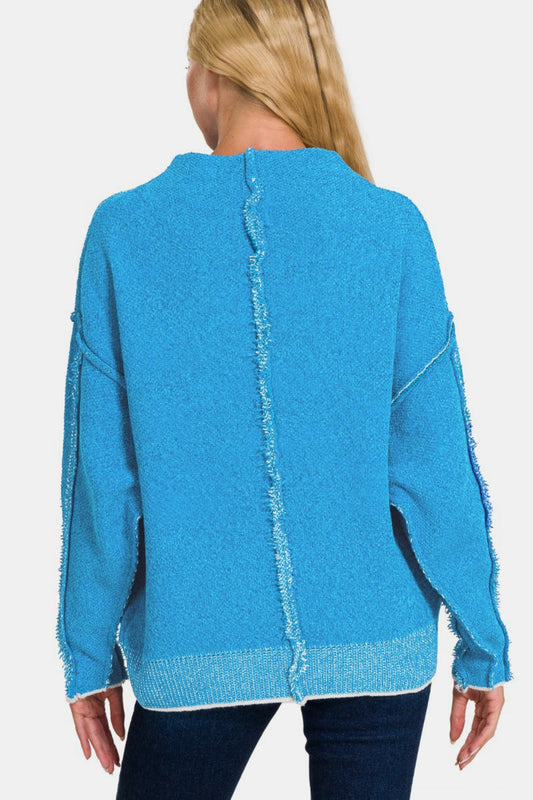 Blue cozy exposed seam mock neck sweater with long sleeves, slightly stretchy material, polyester-acrylic blend.