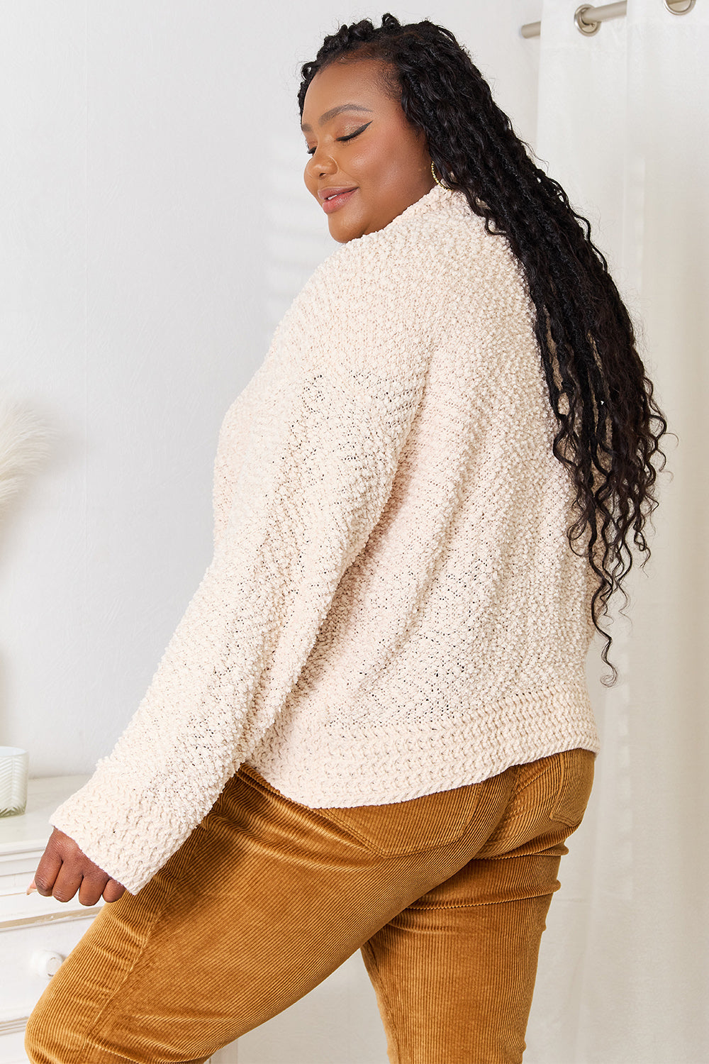 Woman wearing cozy cream cardigan with long sleeves, ideal for fall fashion layering, showcasing soft and textured acrylic fabric.