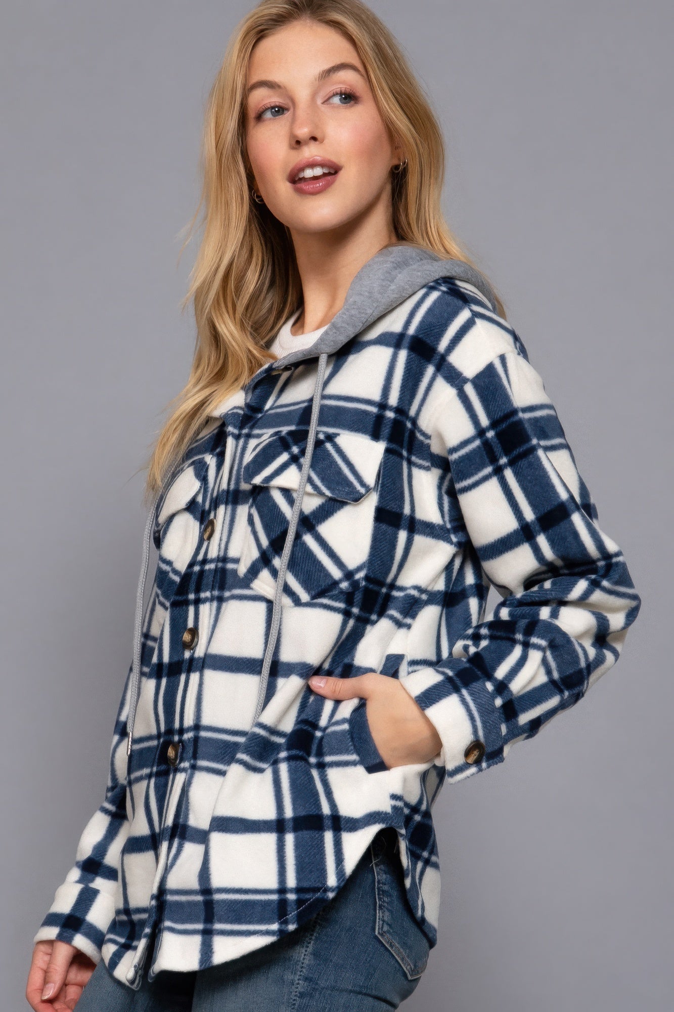 Woman wearing ivory and navy plaid fleece hoodie jacket with button-down closure and hood