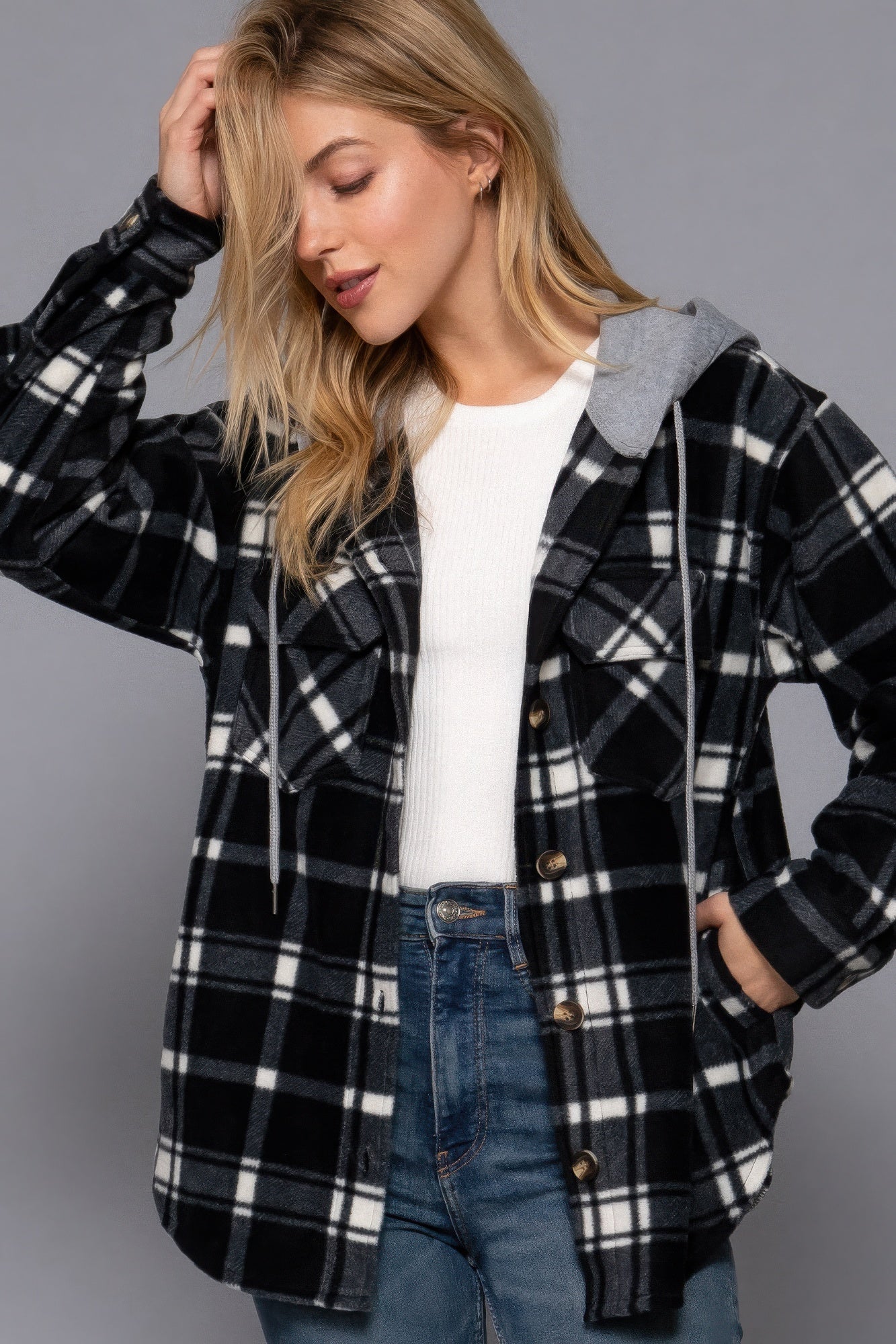 Woman wearing plaid print hoodie fleece jacket with button-down closure and hood, perfect for casual outings or layering in cool weather.