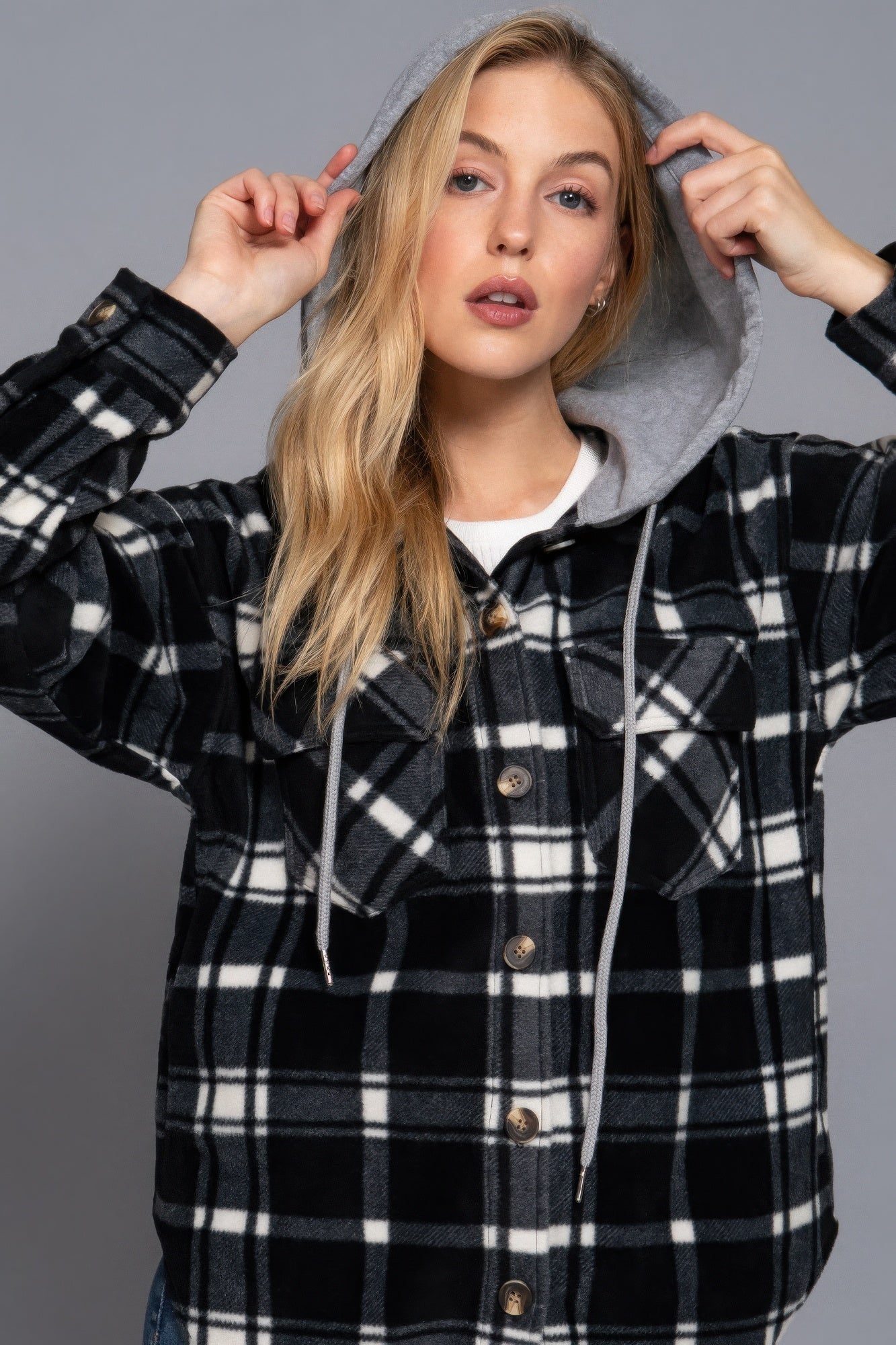 Woman wearing ivory/navy plaid print hoodie fleece jacket with button-down closure and hood.