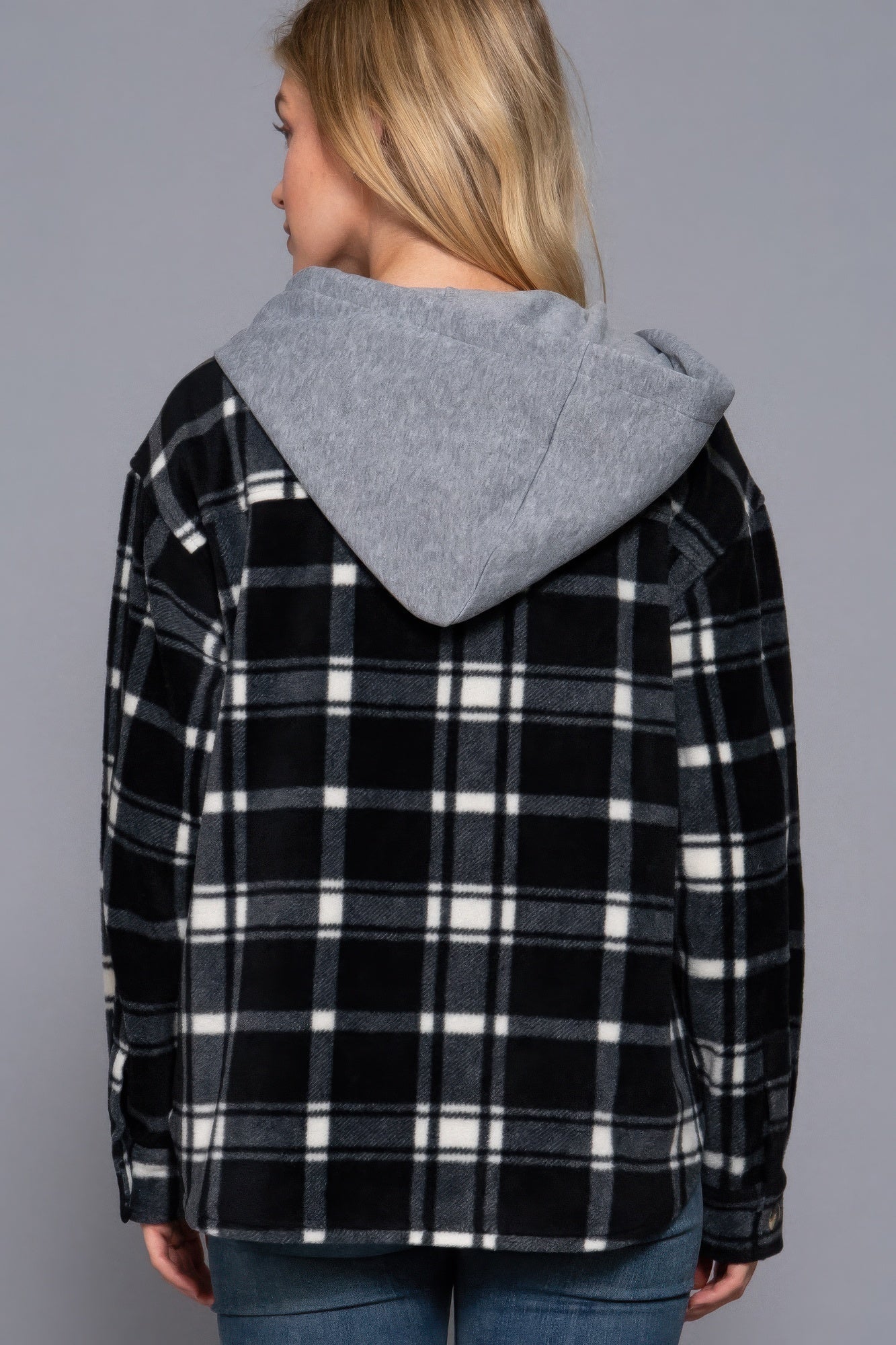 Woman wearing plaid print hoodie fleece jacket with gray hood, back view