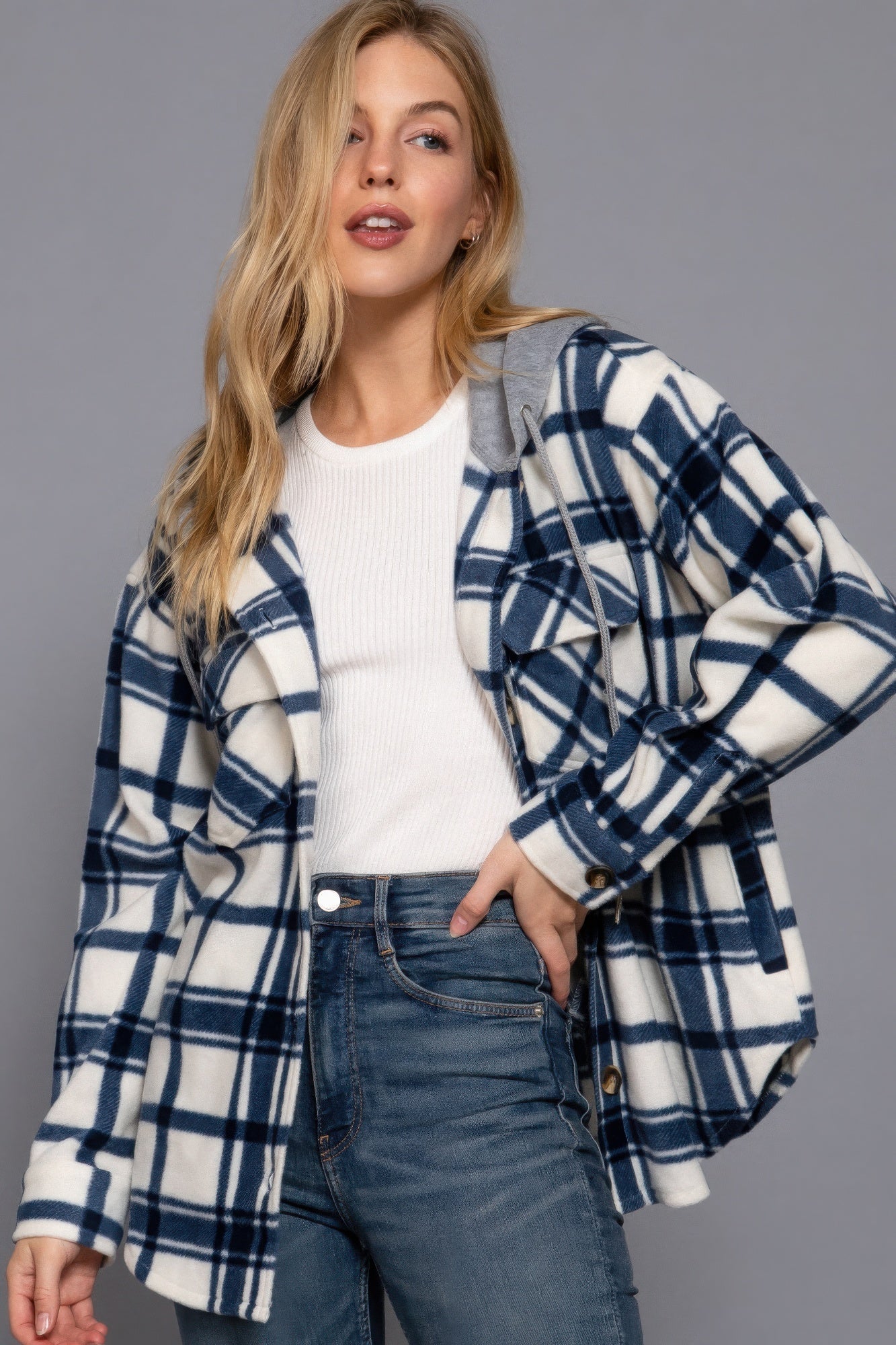 Woman wearing ivory/navy plaid print fleece hoodie jacket with long sleeves and button-down closure, perfect for casual layering.