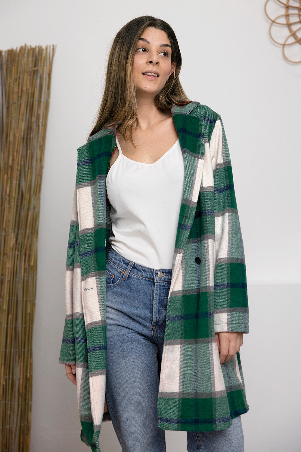 Woman wearing full-size plaid button-up lapel collar coat in green and white, styled with jeans and a white top.